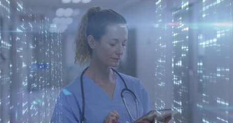 Analyzing nurse wearing scrubs with stethoscope holding tablet with overlay in hospital corridor