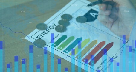 Analyzing right hand marking energy efficiency rating sheet on desk, with coins and chart overlays