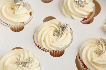 Delicious white cupcakes in box for birthday party, closeup