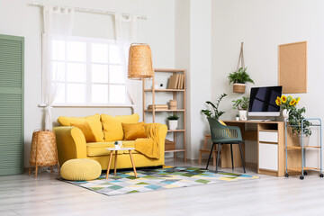 Interior of living room with workplace, sofa and plants