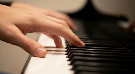 Fototapeta premium Close-up of Hands Playing Piano with Focused Fingers on Keys in Warm Indoor Lighting