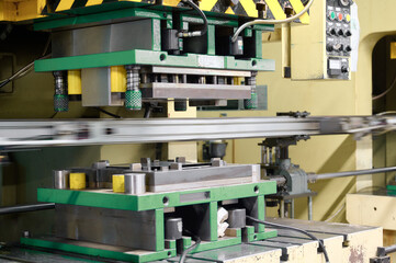 Cold metal stamping press operating in a manufacturing facility during daytime work hours