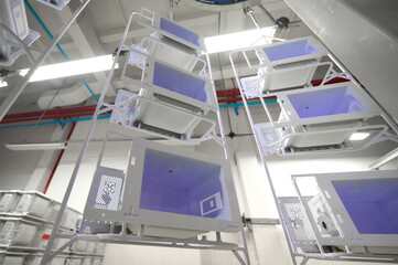 Powder coating workshop featuring microwave oven casings on a conveyor system in a modern facility