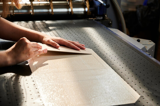 Manual cardboard application in a vibrant box manufacturing facility during a busy working day