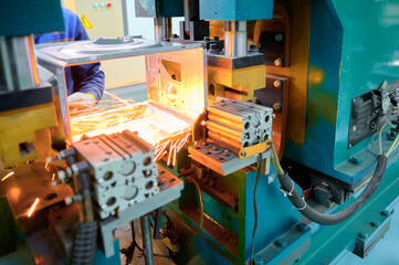Spot welding process taking place on microwave oven casing in a manufacturing facility under...