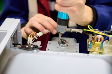 Assembly process of microwave oven electrical components on a conveyor line in a manufacturing facility