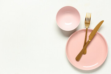 Beautiful table setting with golden cutlery on white background