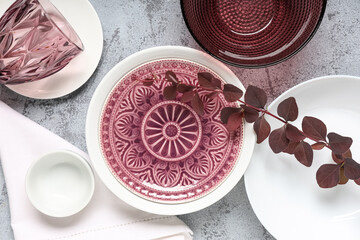 Beautiful table setting with purple branch on grey background
