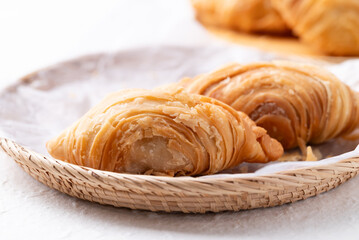 Thai curry puff stuffed with chicken or sweet potatoes in basket on white background
