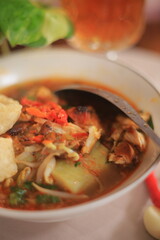 Bowl of Authentic Soto Ayam with Shredded Chicken and Aromatic Spices