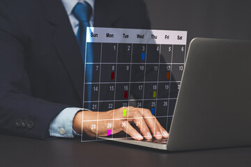 Businessman using laptop with digital calendar schedule.