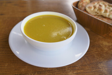 Delicious yellow soup served with bread in a cozy restaurant