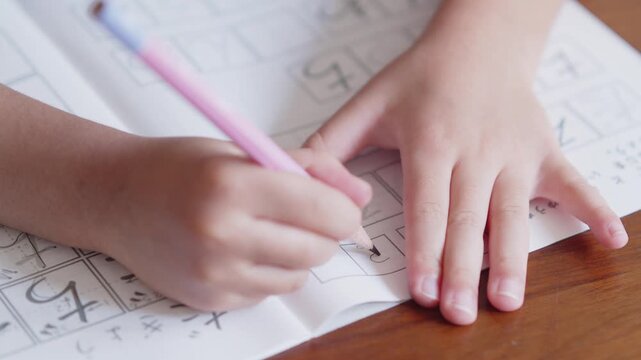 ひらがなを書く練習をする5歳の男の子の手元