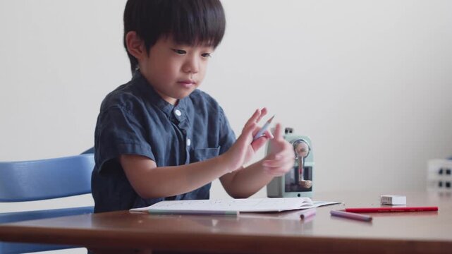 ひらがなのを書く練習をする5歳の男の子	