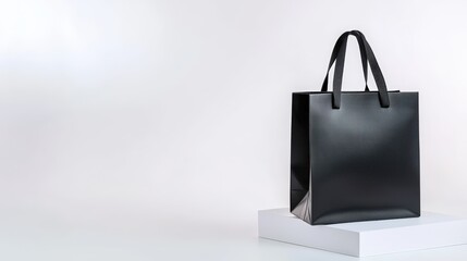 A matte black shopping bag with subtle branding, studio-lit on a white base, open text area on the left.