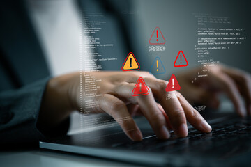 Close-up hand of businessperson typing on laptop with programming code and warning alert. Cybersecurity threat, coding error, system vulnerability and data breach risk in software development concept.