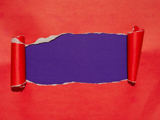 A torn red paper revealing an underlying purple layer.