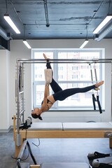 Fototapeta premium Caucasian woman doing pilates on reformer. 