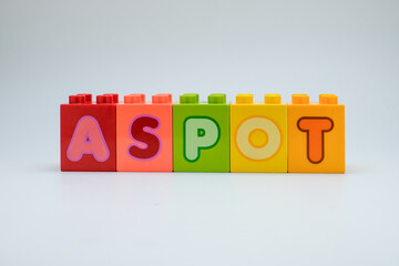 Colorful plastic toy blocks with alphabet letters arranged in a row on white background. Concept of education, learning, childhood creativity, and playful design. Perfect for school, kids education