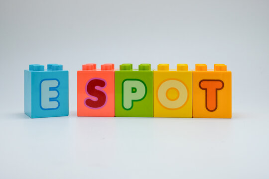 Colorful plastic toy blocks spelling the word E SPOT with alphabet letters arranged in a row on white background. Concept of education, learning, childhood creativity, and playful design