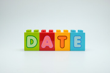 Colorful toy blocks spelling the word DATE on a clean white background. Perfect for illustrating calendar dates, events, data, and educational projects