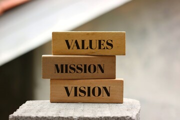 Stacked Wooden Blocks Highlighting Values, Mission, and Vision Concepts. Set against a blurred...