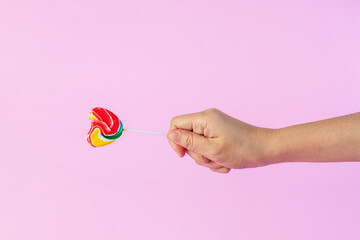 Sweets, two lollipops in hand, on pink background