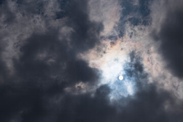 Obraz premium Dramatic dark clouds almost cover the sun during the day. Climate and weather concept. For graphic design, 3D rendering and banners