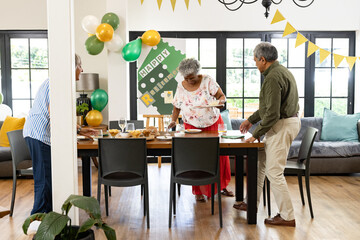 Family preparing festive table for retirement party with decorations and balloons