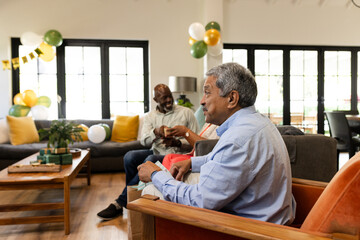 Elderly man enjoying festive gathering with friends in cozy living room setting