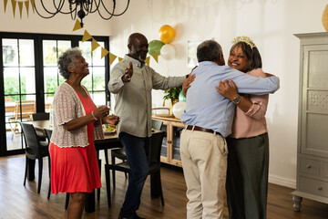 Family celebrating birthday at home, hugging and smiling with decorations around
