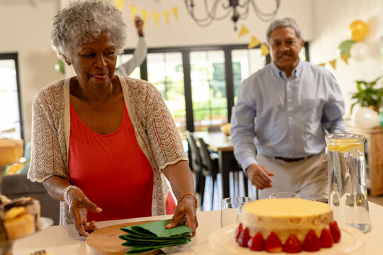 Elderly couple preparing for celebration at home with cake and decorations