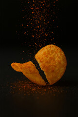 Broker potato chips on black background