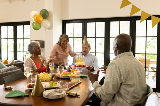 Celebrating birthday at home, family sharing cake and joyful moments with decorations - Powered by Adobe
