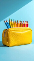 Upright shot of a yellow pencil case filled with colourful pencils against a light blue background with shadows