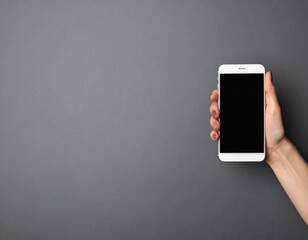 A person's hand holds a white smartphone with a blank screen, set against a dark grey background, presenting a clean modern aesthetic