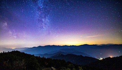A breathtaking expanse of the Milky Way arches above layers of distant, forested mountain ranges beneath a vibrant twilight sky