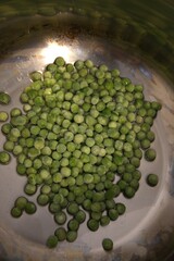 Close-up view of frozen green peas in a cooking pot. Healthy vegetable concept.