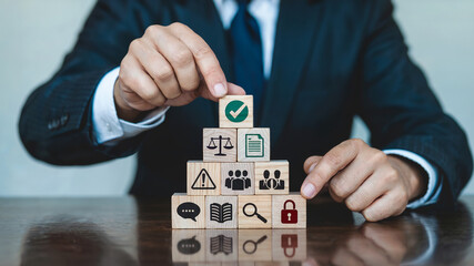 Businessman Stacking Wooden Blocks Representing Regulatory Compliance and Business Management with Check Mark Icon