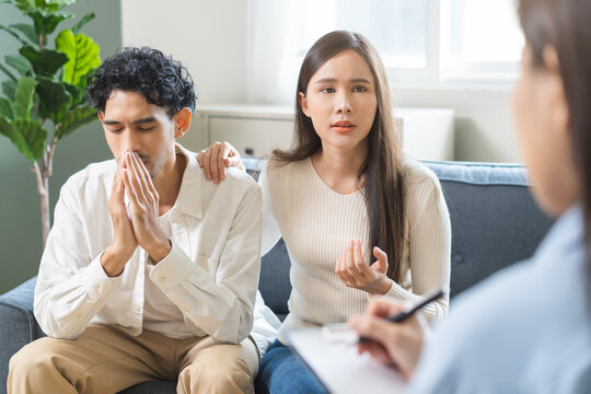 Psychology, depression asian young couple love woman and male patient consulting problem mental health with psychologist, psychiatrist at clinic together, wife encouraging husband, therapy health care - Powered by Adobe