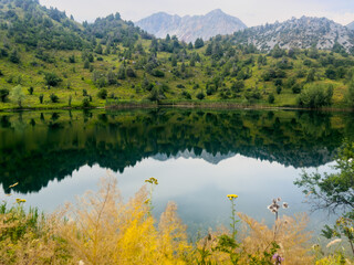 Small alpine lake amid autumn hues in Sary Chelek Biosphere Reserve