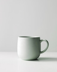 Obraz premium A single modern sage green ceramic mug with a minimalist design, perfect for hot coffee or tea, isolated on a clean white background