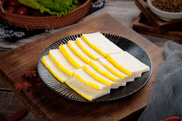 Traditional Asian Tofu Slices with Yellow Filling on Wooden Board - Gourmet Vegetarian Cuisine