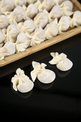 Obraz premium Fresh Wontons in Bamboo Steamer Basket Ready for Cooking Traditional Chinese Dumplings