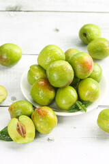 Fresh Green Plums in Bowl on White Wooden Background - Healthy Organic Stone Fruit