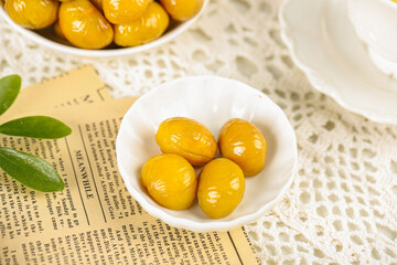 Candied Chestnuts in White Bowls on Vintage Newspaper and Lace Tablecloth