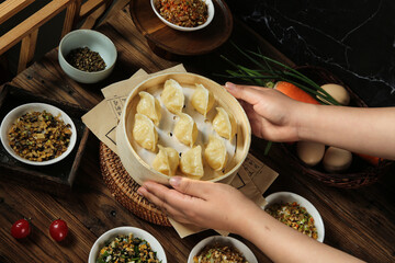 Traditional Handmade Dumplings in Bamboo Steamer with Asian Dipping Sauces and Fresh Ingredients