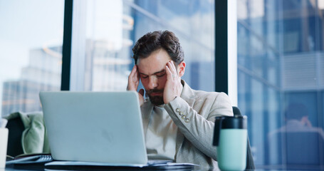Businessman, laptop and headache with stress in office for corporate bankruptcy, debt or pressure....