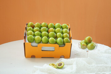 Fresh Green Apricots from Xinjiang in Orange Box Display with Modern Presentation Setup