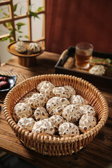 Dried Shiitake Mushrooms in Wicker Basket with Traditional Asian Tea Setting on Wooden Table